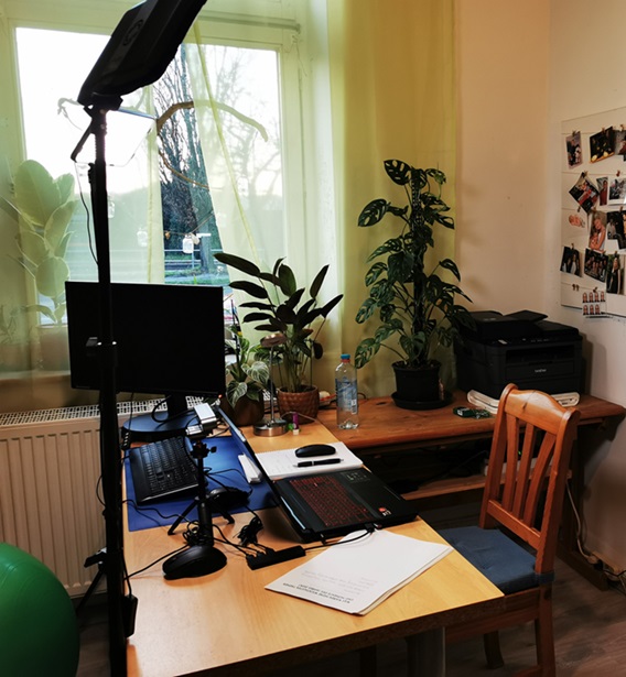 Ein Schreibtisch mit Laptop und PC vor einem Fenster