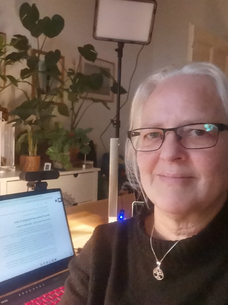 Ein Selfie von Alexandra, die am Schreibtisch vor dem Laptop sitzt, auf dem die Homepage zu sehen ist